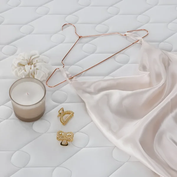 Матрас Fashion Vela: уютная белая текстура с аксессуарами, создающими атмосферу комфорта и роскоши для спальни.