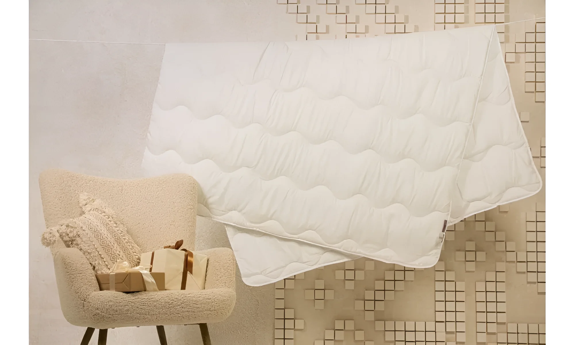 Белый стеганый наматрасник Come-For Basic Light на фоне кресла и декоративных элементов, комфорт и уют в спальне.