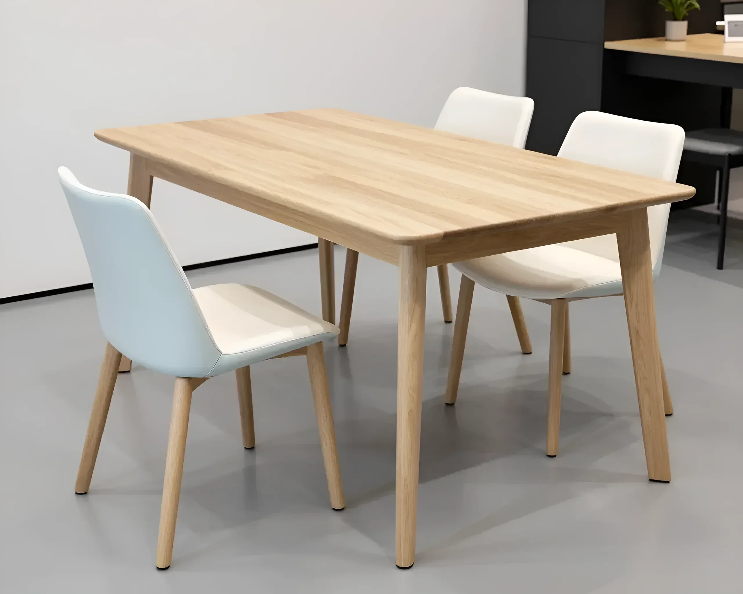 Light wooden dining table with four eco-leather upholstered chairs, set in a modern dining room.
