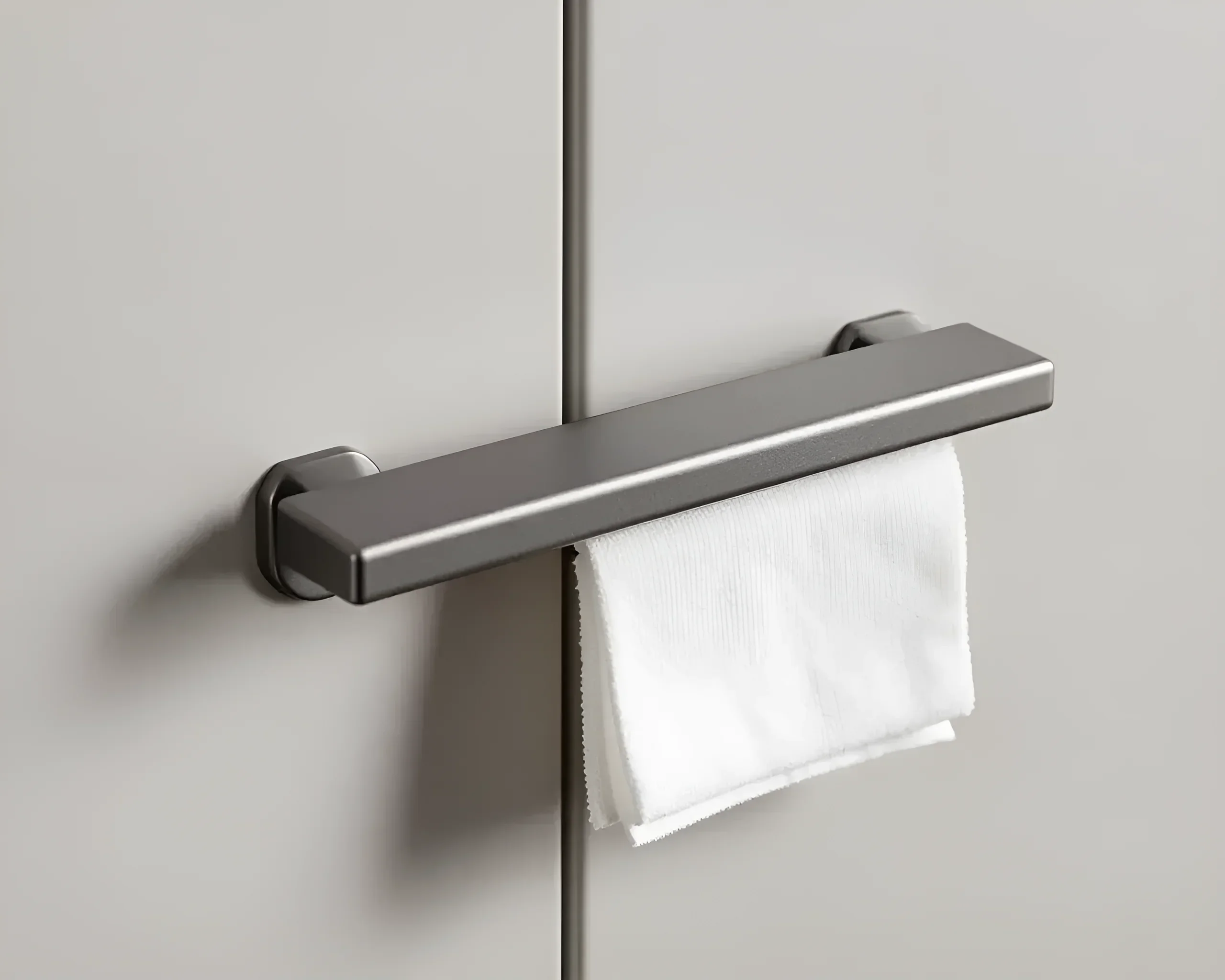 Minimalistischer matter Handtuchhalter, integriert in die Oberfläche eines Schranks, mit einem ordentlich gefalteten weißen Handtuch.