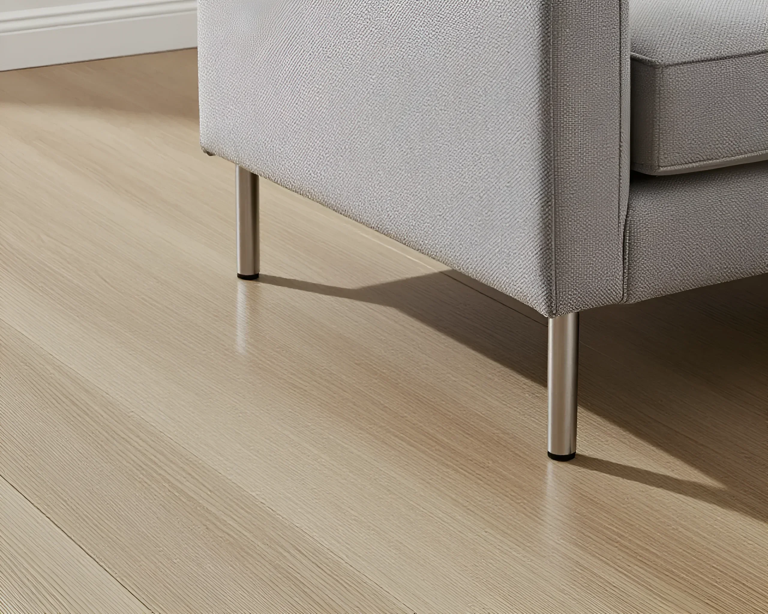 Minimalist gray sofa with thin metal legs on a light wooden floor