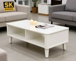 Белый журнальный столик с двумя открытыми полками, стоящий на четырех конических ножках, с журналом и свечами на столешнице.