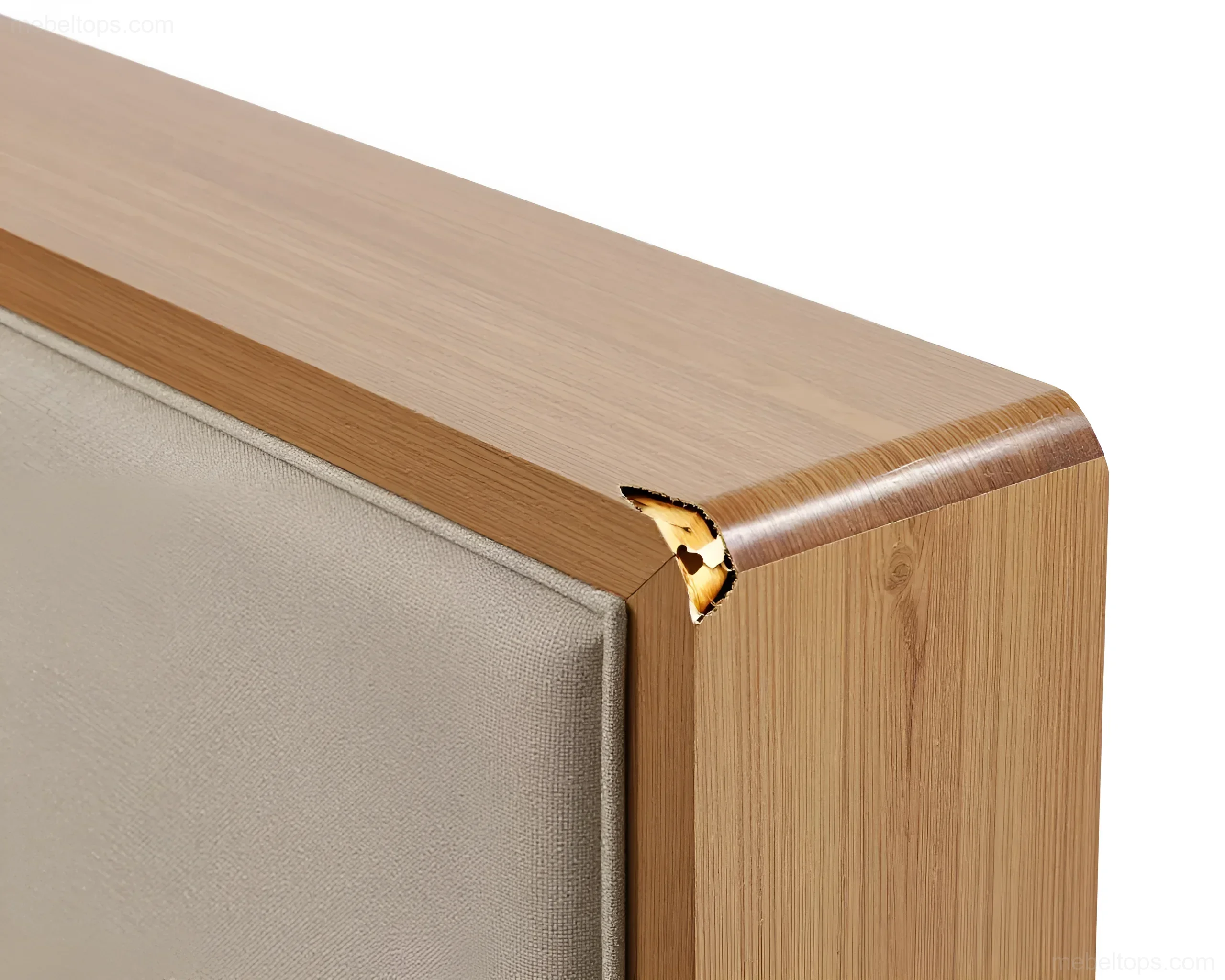Nahaufnahme einer Ecke eines Holzschranks mit einer weichen Textileinlage, die einen Span und den unbearbeiteten Kern des Materials zeigt.
